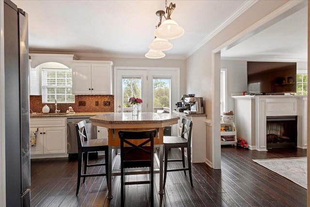 3933 High Chaparral Dr, Martinez, GA 30907 - kitchen with appliances with stainless steel finishes, white cabinets, healthy amount of natural light, dark wood finished floors, and ornamental molding