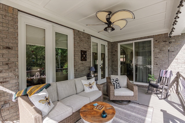 sunroom / solarium with a ceiling fan, outdoor lounge area, and french doors
