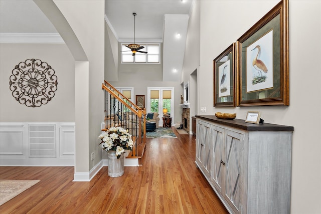 entrance foyer with plenty of natural light, ornamental molding, and light wood-style floors