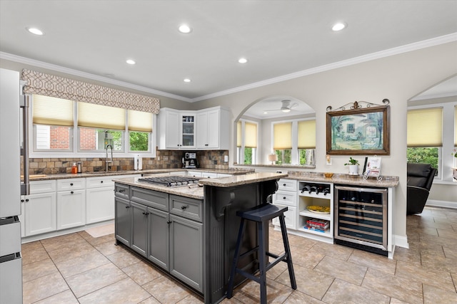 kitchen with arched walkways, gray cabinetry, white cabinetry, and wine cooler