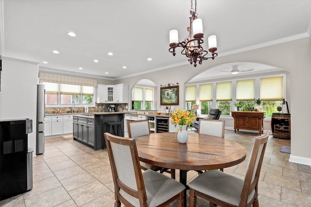 dining area with arched walkways, ornamental molding, ceiling fan with notable chandelier, and recessed lighting