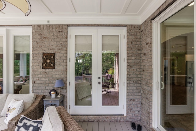 property entrance featuring brick siding and french doors