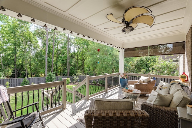 wooden deck with an outdoor hangout area, a ceiling fan, a yard, and a fenced backyard