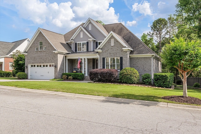 craftsman inspired home featuring an attached garage, a front lawn, brick siding, a porch, and concrete driveway