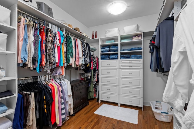 walk in closet with wood finished floors