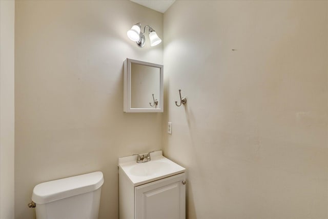 half bath featuring toilet and vanity