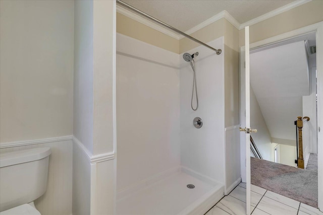 full bathroom featuring a wainscoted wall, toilet, ornamental molding, a textured ceiling, and a shower