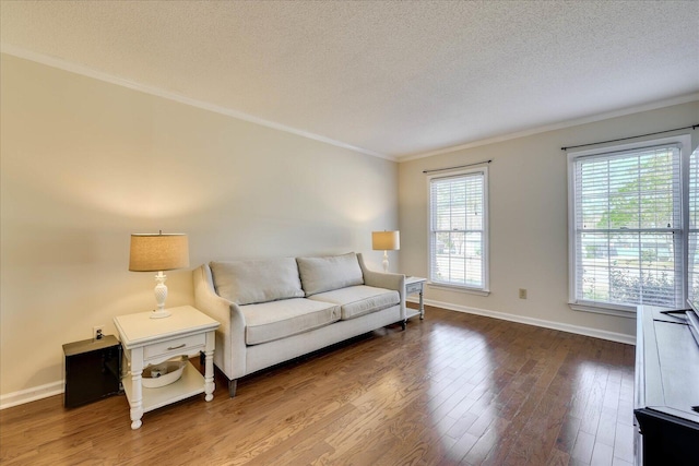 living room featuring baseboards, a textured ceiling, wood finished floors, and crown molding