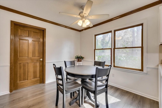 dining room with baseboards, light wood-style floors, ceiling fan, and crown molding