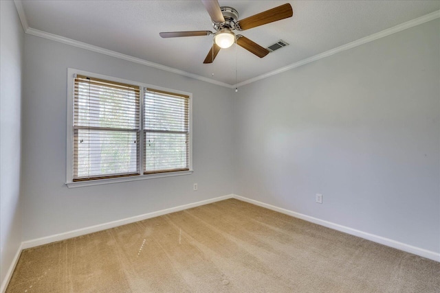 empty room with ornamental molding, a ceiling fan, baseboards, and light carpet