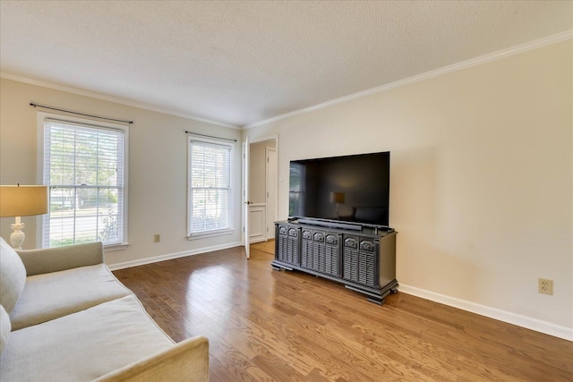 living room with crown molding, wood finished floors, baseboards, and a textured ceiling