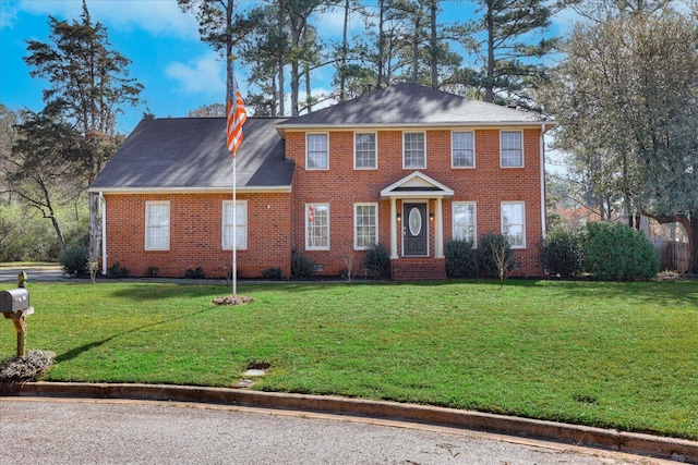 colonial house featuring brick siding, crawl space, and a front lawn