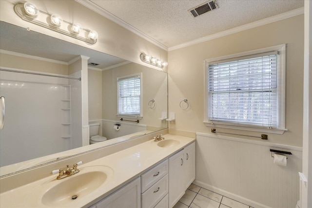 bathroom with a textured ceiling, wainscoting, visible vents, and a sink