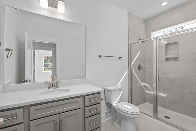 bathroom with tile patterned flooring, vanity, toilet, and a shower with shower door