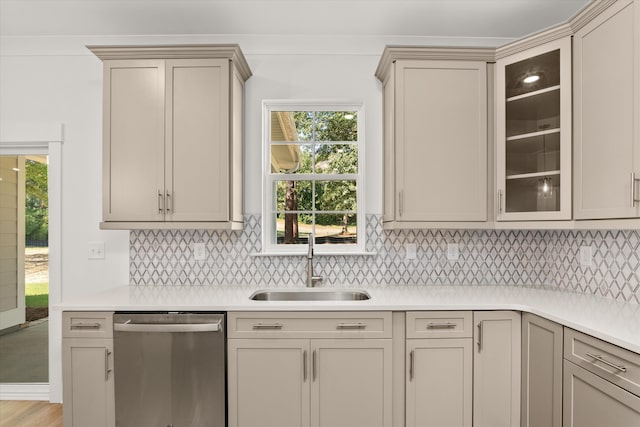 kitchen with dishwasher, backsplash, sink, cream cabinetry, and light hardwood / wood-style floors