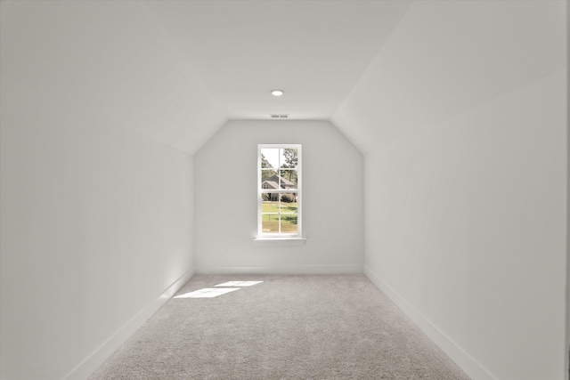 bonus room with carpet flooring and vaulted ceiling