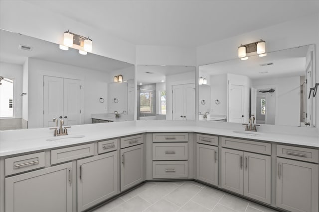 bathroom with tile patterned flooring, vanity, and walk in shower