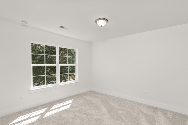 unfurnished room featuring light colored carpet and plenty of natural light