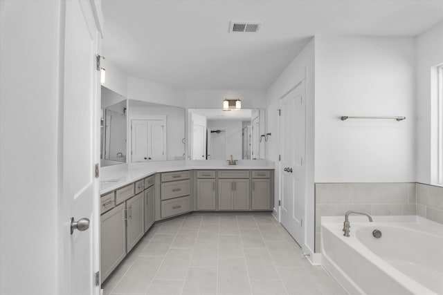 bathroom with tile patterned flooring, vanity, and a washtub