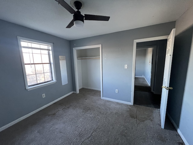 unfurnished bedroom with ceiling fan, a closet, and dark carpet