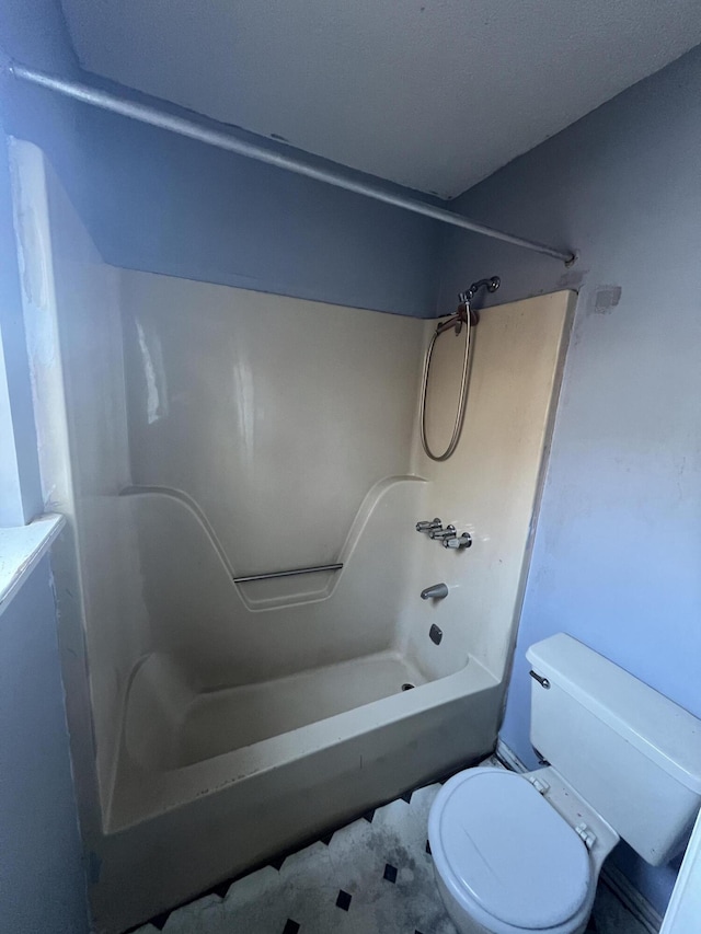 bathroom featuring shower / bathing tub combination and toilet