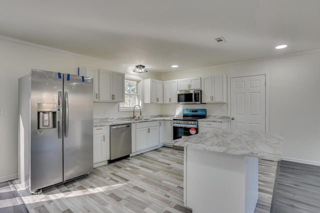 kitchen featuring sink, crown molding, white cabinetry, light wood-type flooring, and appliances with stainless steel finishes