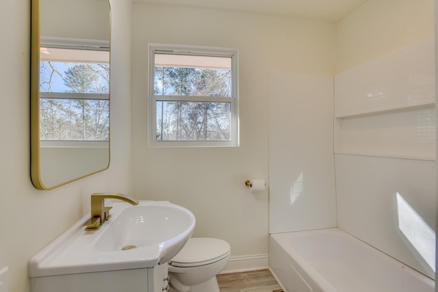 full bathroom featuring toilet, a wealth of natural light, sink, and hardwood / wood-style floors