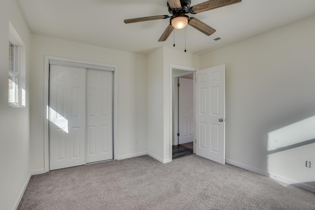 unfurnished bedroom with ceiling fan, a closet, and light colored carpet