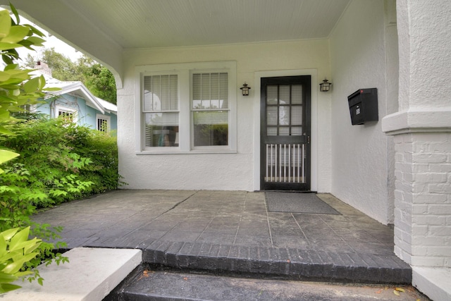 entrance to property featuring stucco siding