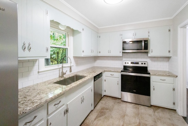 kitchen featuring white cabinets, appliances with stainless steel finishes, light stone counters, and sink