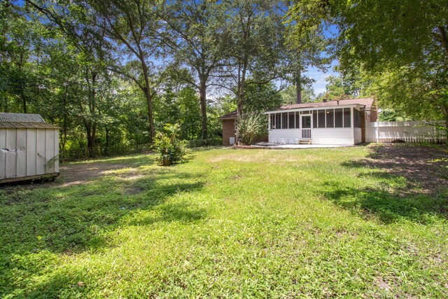 view of yard with a sunroom and a storage shed