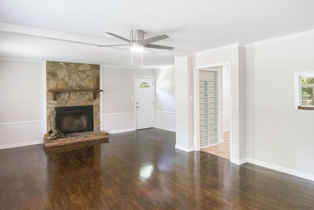 unfurnished living room featuring dark wood-type flooring, a stone fireplace, ceiling fan, and crown molding