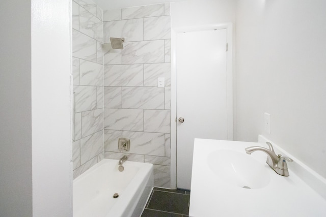 bathroom with tiled shower / bath combo, tile patterned floors, and sink