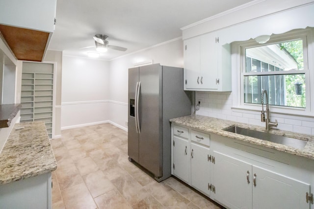 kitchen featuring tasteful backsplash, stainless steel fridge, sink, and white cabinets