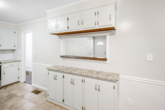 kitchen featuring decorative backsplash, white cabinetry, and ornamental molding