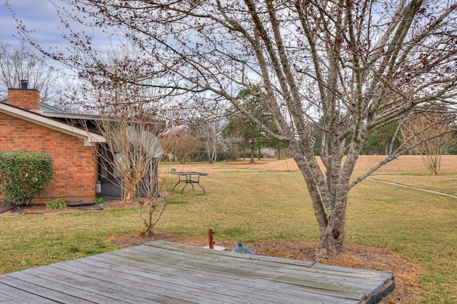 wooden terrace featuring a yard