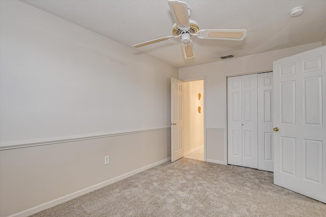 unfurnished bedroom featuring a ceiling fan, carpet, visible vents, baseboards, and a closet