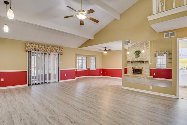 unfurnished living room with visible vents, beam ceiling, and wood finished floors