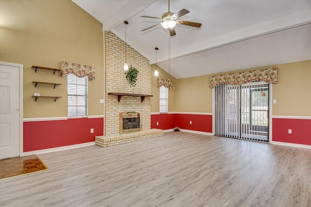 unfurnished living room with wood finished floors, plenty of natural light, ceiling fan, and a fireplace