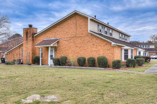 view of home's exterior with a yard, brick siding, and a chimney