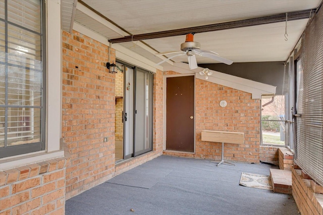 unfurnished sunroom with lofted ceiling and a ceiling fan