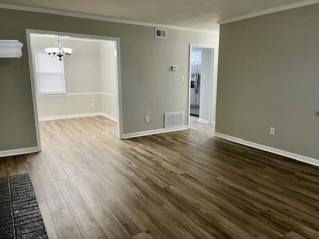 141 Glenora Dr, Martinez, GA 30907 - unfurnished room featuring ornamental molding, visible vents, a chandelier, and dark wood finished floors