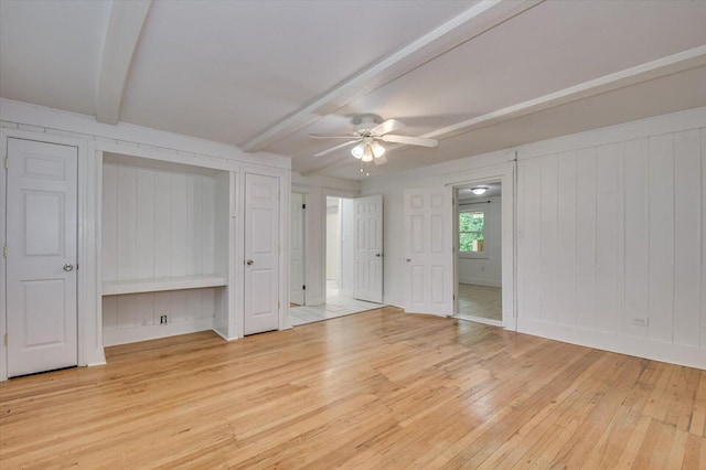 unfurnished bedroom with beam ceiling, ceiling fan, and light wood-type flooring