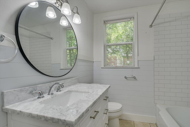 full bathroom featuring toilet, vanity, tile patterned floors, and tiled shower / bath combo