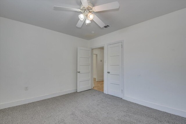 empty room featuring ceiling fan and light carpet