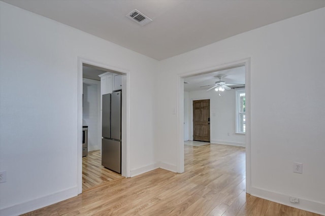 spare room featuring ceiling fan and light hardwood / wood-style flooring