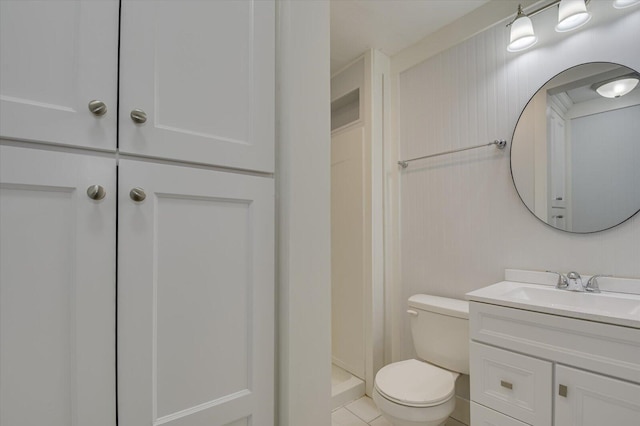 bathroom featuring tile patterned flooring, vanity, toilet, and a shower