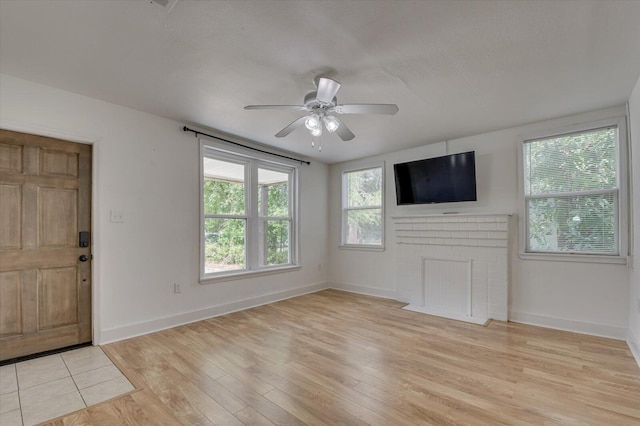 unfurnished living room with light wood-type flooring and ceiling fan