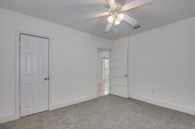 carpeted spare room with ceiling fan