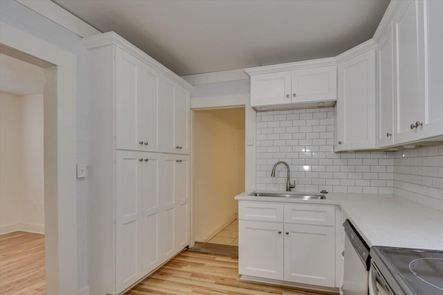 kitchen featuring dishwasher, tasteful backsplash, white cabinetry, and sink